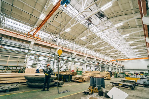 Trabajador controla grúa de viga con control remoto en taller de carpintería — Foto de Stock