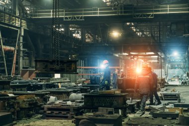 Metal kalıpları olan üretim hattındaki işçiler endüstriyel metalurji atölyesinde çalışıyor. Ağır sanayi