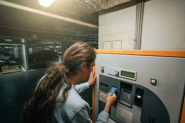 Man membayar parkir bawah tanah di Mall dengan mesin khusus dengan kartu bank — Stok Foto