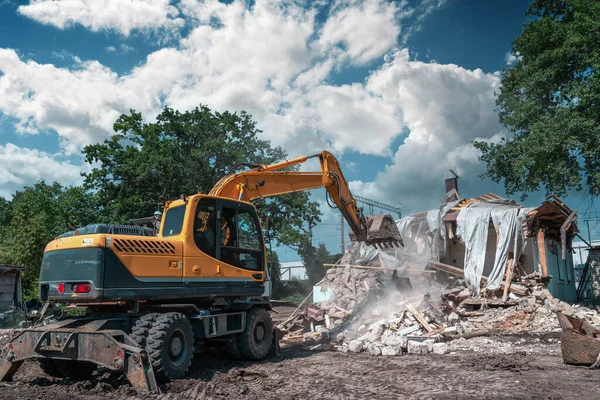 Pembongkaran bangunan. Excavator merusak rumah tua. Membebaskan ruang untuk pembangunan gedung baru — Stok Foto