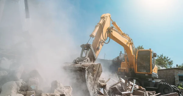 Penghancuran rumah tua oleh penggali. Ember ekskavator menghancurkan struktur beton — Stok Foto