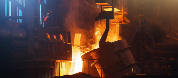 Metallurgical plant. Molten metal pouring from big ladle. Iron cast process. Industrial steel production. Steel mill factory. Heavy industry foundry