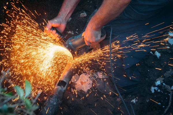 Arbeiter schneidet Gasrohr mit Schleifer durch und viele Funken fliegen aus nächster Nähe — Stockfoto