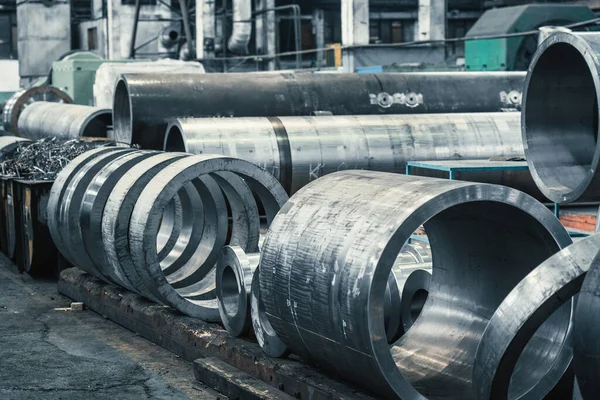 Tubos de metal redondos grandes na oficina da fábrica. Produção de tubagens ou tubos de aço para indústria pesada — Fotografia de Stock