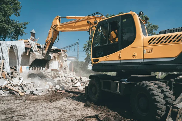 Penghancuran rumah tua oleh penggali. Ember ekskavator menghancurkan struktur beton — Stok Foto