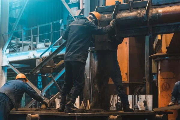 Arbeiter bei der Arbeit mit großen Gusseisen auf Stahlwerk. Innenraum der Gießerei-Werkstatt. Typische metallurgische Anlage — Stockfoto