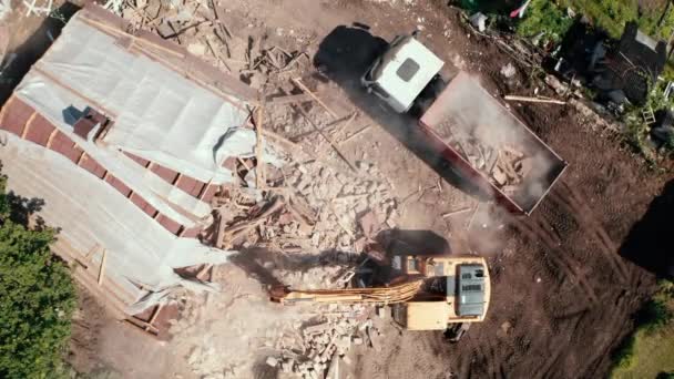 Demolição do edifício da casa para a construção nova. Lixo de carga do balde da escavadeira no caminhão, vista aérea — Vídeo de Stock