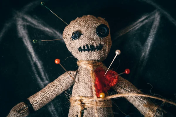 Voodoo szmaciana lalka z przyciskami zamiast oczu i nabita igłami, widok z bliska góry — Zdjęcie stockowe