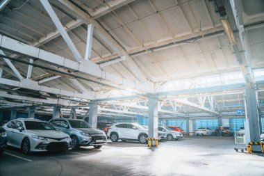 Alışveriş merkezinin otoparkında ya da alışveriş merkezinde insanlar olmadan park edilmiş bir sürü araba var.