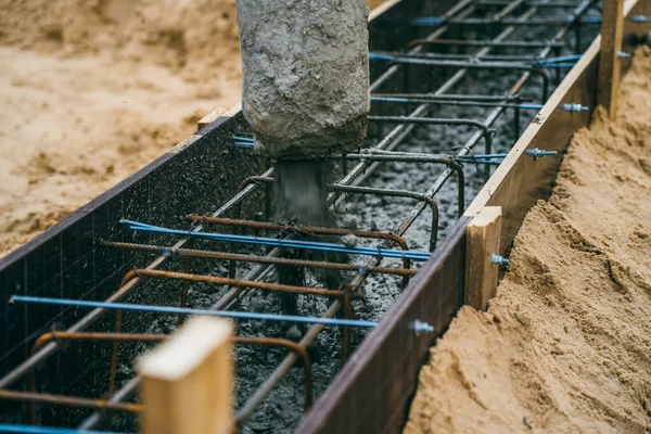 Verter cemento u hormigón con bomba automática, sitio de construcción con cimentación de parrilla reforzada, inicio de la construcción de viviendas nuevas —  Fotos de Stock