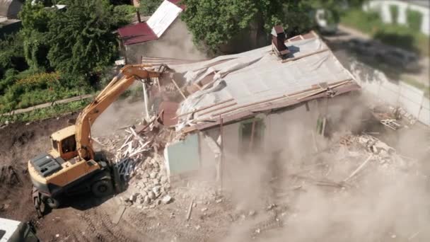 掘削機のバケツ、空中ビューによる新しい建設のための古い家の建設プロセスの解体。都市開発 — ストック動画
