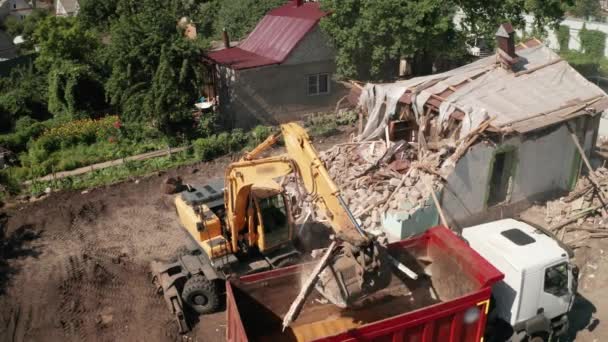 Demolizione di costruzione di case per la nuova costruzione. Secchio escavatore carico spazzatura in camion, Vista aerea — Video Stock