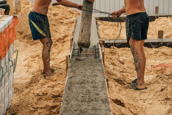 Verter cemento u hormigón con bomba automática, sitio de construcción con cimentación de parrilla reforzada, inicio de la construcción de viviendas nuevas —  Fotos de Stock