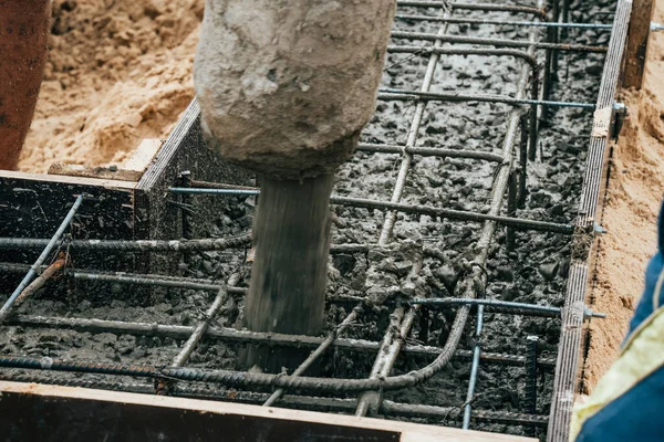 Verter cemento u hormigón con bomba automática, sitio de construcción con cimentación de parrilla reforzada, inicio de la construcción de viviendas nuevas —  Fotos de Stock