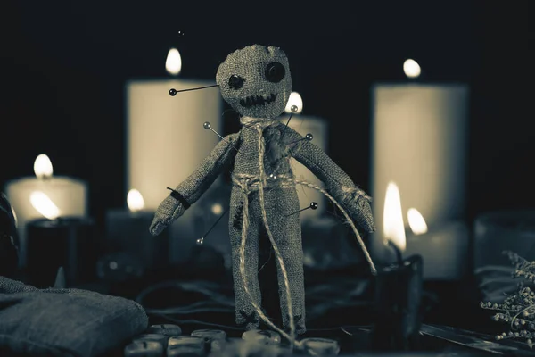 Koncepcja magii voodoo. Lalka voodoo nabita igłami z przekłutym szmacianym sercem na pentagramie i wokół palących się świec. Straszny lub dziwaczny magiczny rytuał ezoteryczny, czarno-białe zdjęcie — Zdjęcie stockowe