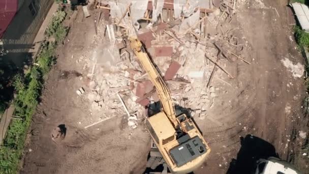 La excavadora hidráulica rompe la casa. Demolición o destrucción de edificios para nueva construcción, vista aérea superior — Vídeos de Stock