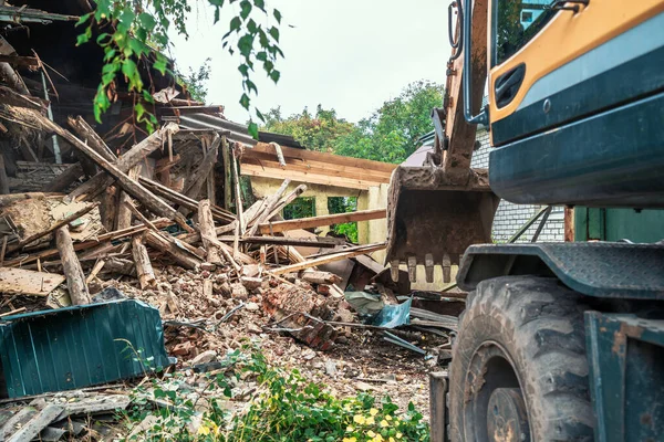 Penghancuran rumah. Dinding rusak bangunan tua dan ekskavator di lokasi konstruksi masa depan — Stok Foto
