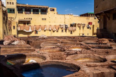 UNESCO 'nun Dünya Mirası bölgesi Fes el-Bali' de bulunan Chouara Tabakhanesi 'nde deri boyamak için kullanılan antik taş varillerinin çarpıcı yüksek açılı görüntüsü. Resim geleneksel zanaat sürecini renkli varillerle tasvir ediyor, gizleniyor