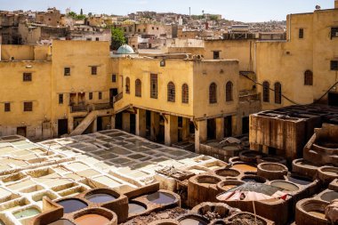 UNESCO 'nun Dünya Mirası bölgesi Fes el-Bali' de bulunan Chouara Tabakhanesi 'nde deri boyamak için kullanılan antik taş varillerinin çarpıcı yüksek açılı görüntüsü. Resim geleneksel zanaat sürecini renkli varillerle tasvir ediyor, gizleniyor