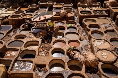 UNESCO 'nun Dünya Mirası bölgesi Fes el-Bali' de bulunan Chouara Tabakhanesi 'nde deri boyamak için kullanılan antik taş varillerinin çarpıcı yüksek açılı görüntüsü. Resim geleneksel zanaat sürecini renkli varillerle tasvir ediyor, gizleniyor