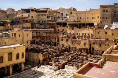 UNESCO 'nun Dünya Mirası bölgesi Fes el-Bali' de bulunan Chouara Tabakhanesi 'nde deri boyamak için kullanılan antik taş varillerinin çarpıcı yüksek açılı görüntüsü. Resim geleneksel zanaat sürecini renkli varillerle tasvir ediyor, gizleniyor