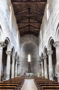 Viterbo 'daki Santa Maria Nuova Kilisesi' nin merkez sahasına resmi bir bakış açısı. Görüntü, 12. yüzyılın saf Roma mimarisini gözler önüne seriyor, monolitik peperino taş sütunlar, oyulmuş başkentler, ahşap bir kiriş tavanı ve