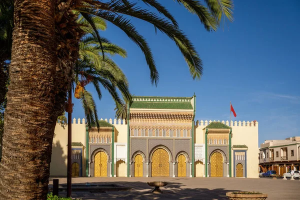 Fes Kraliyet Sarayı 'nın ikonik yedi altın kapısının çarpıcı güneşli manzarası. Görüntü, altın kapılı Fas mimarisini, yeşil ve mavi tonlarında karmaşık zellij mozaik kaplamasını ve ince oyulmuş ce