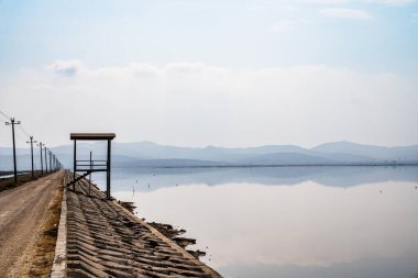 Vjose-Narte Korunaklı Peyzaj 'ın içindeki Narta Lagoon' un çevresindeki Ngjoli Yolu boyunca yer alan ahşap bir kuş izleme kulesinin perspektif görüntüsü. Bu manzaralı güzergah tuz tavaları boyunca uzanır ve sp için birincil varış noktasıdır
