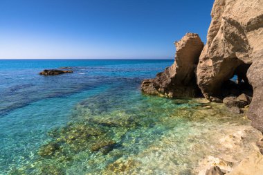 Tropea 'daki doğal bir körfezin yakın görüntüsü, kristal berrak bir denize bakan kireç taşı oluşumları zümrüt yeşilinden koyu maviye kadar uzanan renklerle. Calabria 'nın kalbinde bozulmamış bir kıyı manzarası.