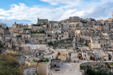 Matera 'nın antik troglodit yerleşiminin yer aldığı geniş açılı bir çekim. Evleri ve kiliseleri tüy taşına oyulmuş. Görüntü, Kanyon 'un kıyısına tünemiş Sasso Caveoso bölgesinin yoğun tarihi yapısını vurguluyor.