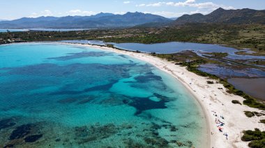 Sardinya 'daki dünyaca ünlü Cala Brandinchi ve Lu Impostu plajlarını çeken çarpıcı bir yüksek açılı drone. Görüntü canlı turkuaz suları, el değmemiş beyaz kumlu kıyıları ve dramatik b 'ye karşı kurulmuş eşsiz kıyı lagün sistemini sergiliyor.