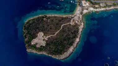 Porto Palermo 'nun tarihi kalesinin yüksek açılı insansız hava aracı görüntüsü, Güney Arnavutluk' un İyon kıyıları boyunca Porto Palermo Körfezi 'nde yer alan küçük bir yarımadada yer alan üçgen şeklinde bir kale. Tepelena 'lı Ali Paşa tarafından inşa edilmiş, iyi korunmuş bir tahkimat...