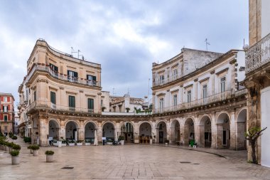 Martina Franca 'daki Piazza Maria Immacolata manzarası. Hafif taşta yarı dairesel zarif Barok portalları, uzun balkonlu asil saraylar ve Itria Vadisi, Puglia, İtalya 'nın tipik asfaltları..
