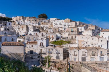 Monte Sant 'Angelo' nun beyaz köyünün manzarası. Resim, İtalya 'nın Puglia kentindeki UNESCO Dünya Mirası sahasında tipik çatıları ve beyaz yüzlü Gargano yamacından aşağı dökülen karakteristik kireçtaşı evleri gösteriyor..