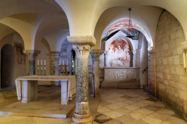 Trani 'deki San Nicola Mahzeni' nin canlandırıcı iç görüntüsü. Çekimde Roma sütunları, kubbeli tavanlar, bir merasim sunağı ve katedralin Puglia, İtalya 'daki yeraltı dünyasının kutsal ve antik atmosferini yakalayan fresk bir oyuk yer alıyor..