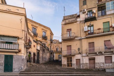 Bronte 'deki ünlü merdiven manzarası, Etna Dağı' ndan klasik merdiven binaları ve lav taşı basamakları. Bu Sicilya köyünün tarihini ve geleneksel mimarisini parlak bir gökyüzü altında yakalayan otantik bir bakış..