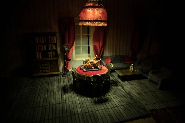 Thanksgiving holiday creative concept. A realistic dollhouse living room with furniture and window at night. Thanksgiving Turkey miniature on table. Selective focus