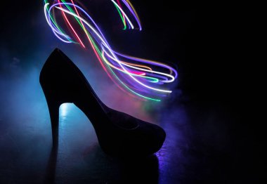 Sanat dekorasyonu. Karanlıkta topuklu kadın ayakkabılarının silueti. Kadın gücü ya da kadın egemenliği kavramı. Seçici odak