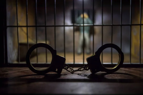 刑務所の男バーのコンセプトの後ろに男 古い汚いグランジ刑務所のミニチュア 手錠で暗い刑務所のインテリア創造的な装飾 選択的焦点 — ストック写真