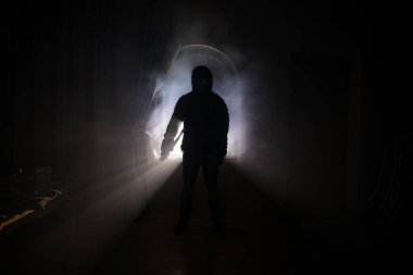 Kapalı cam bir kapıdan geçen, bilinmeyen bir gölge figürünün silueti. Geceleri pencerenin önündeki bir insanın silueti. Manyağın bulanık silueti korkunç cadılar bayramı konsepti.