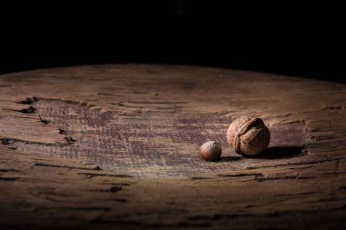 Fındık yemeği konsepti. Ceviz çekirdekleri ve eski ahşap masadaki cevizlerle dolu bir hayat. Yaratıcı masa dekorasyonu. - Yakın çekim. Seçici odak