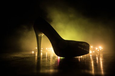 Sanat dekorasyonu. Karanlıkta topuklu kadın ayakkabılarının silueti. Kadın gücü ya da kadın egemenliği kavramı. Seçici odak