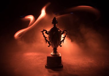 Altın kupa masa arkasında fotokopi alanı olan bir kupa. Renkli sisli arka ışıklandırmalı yaratıcı sanat dekorasyonu. Seçici odak