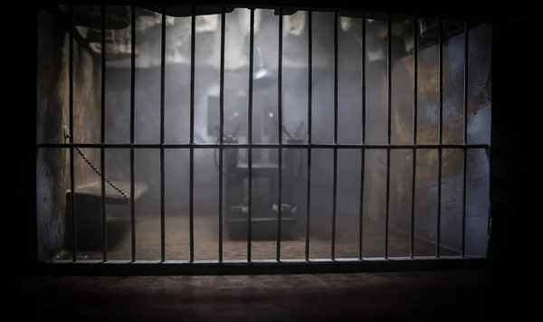 执行概念 死刑电椅缩影在旧监狱的特定焦点 老监狱的铁窗锁创意艺术装饰 黑暗中的电椅天平模型 — 图库照片