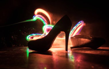 Sanat dekorasyonu. Karanlıkta topuklu kadın ayakkabılarının silueti. Kadın gücü ya da kadın egemenliği kavramı. Seçici odak