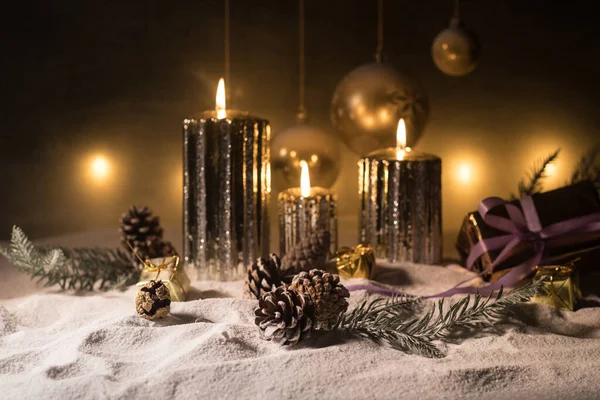 暗い背景に燃えるろうそくとクリスマスの装飾 ライトと暗い黄金の背景の上にクリスマスの装飾 創作物の装飾 — ストック写真