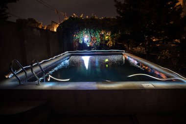 Gece havuzu, tatil geçmişi. Renkli ışık süslemesi. Dondurucu Işık