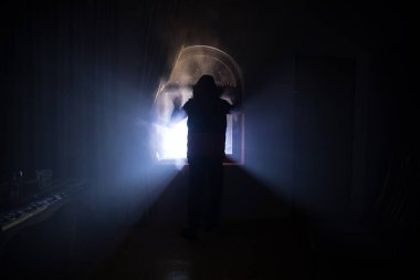 Kapalı cam bir kapıdan geçen, bilinmeyen bir gölge figürünün silueti. Geceleri pencerenin önündeki bir insanın silueti. Manyağın bulanık silueti korkunç cadılar bayramı konsepti.