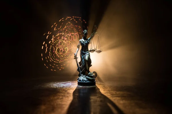 Law concept. Miniature colorful artwork decoration with fog and backlight. The Statue of Justice - lady justice or Iustitia / Justitia the Roman goddess of Justice. Selective focus