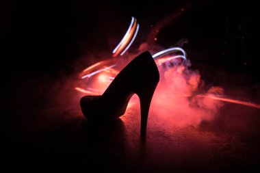 Sanat dekorasyonu. Karanlıkta topuklu kadın ayakkabılarının silueti. Kadın gücü ya da kadın egemenliği kavramı. Seçici odak